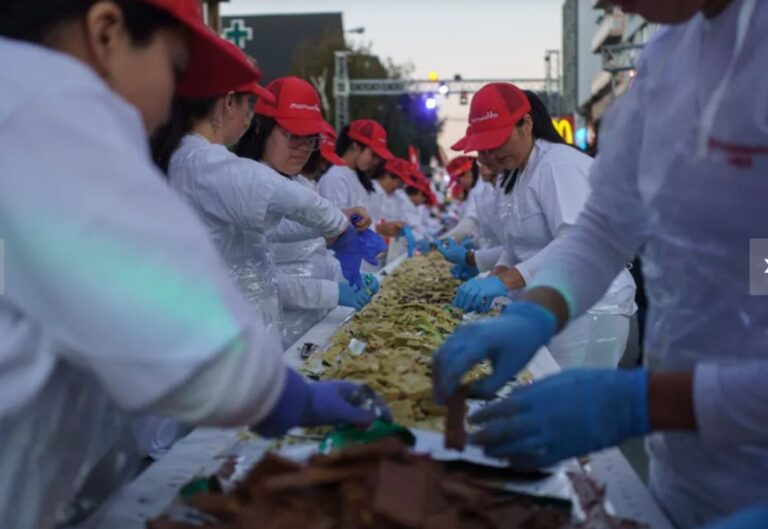 Maestros chocolateros trabajando en la barra de chocolate más larga del mundo durante la Fiesta Nacional del Chocolate en Bariloche.