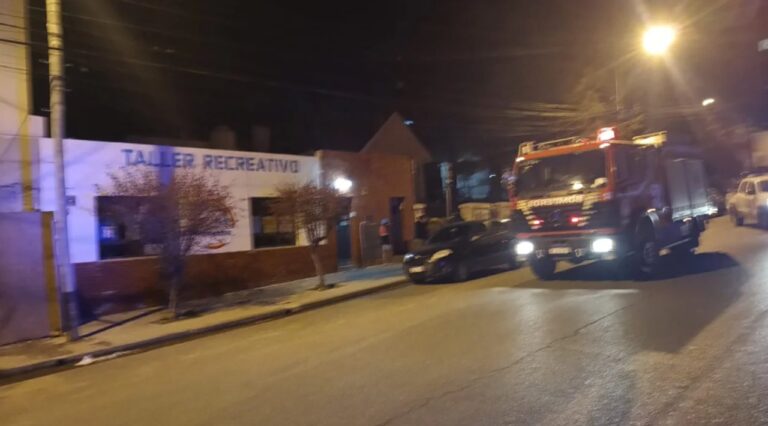 Ilustración genérica de una vela en memoria, con fondo desenfocado de un barrio.
