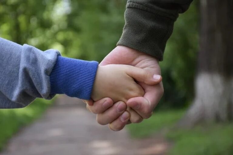 Dos niños hermanos abrazados en un parque