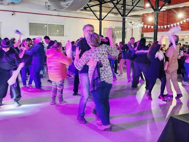 Público y artistas en un escenario durante un evento folklórico en Comodoro Rivadavia.