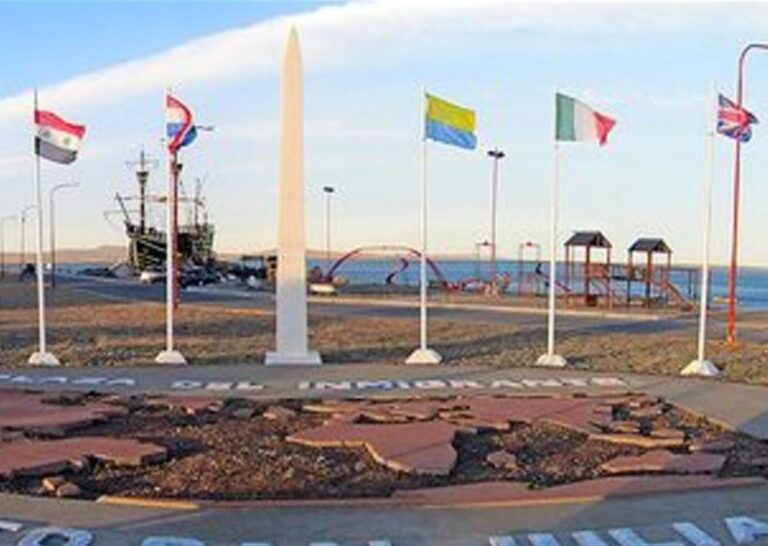 Hombre retira bandera del Reino Unido de un mástil en la Plaza de los Inmigrantes, Puerto San Julián.