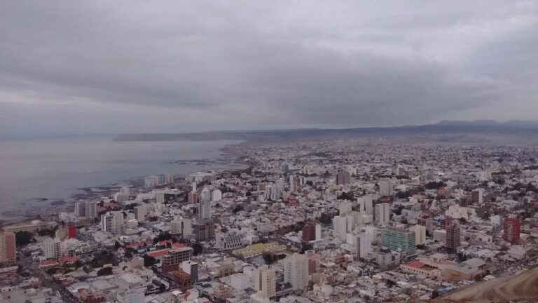 Vista de Comodoro Rivadavia con cielo nublado y banderas ondeando por el viento
