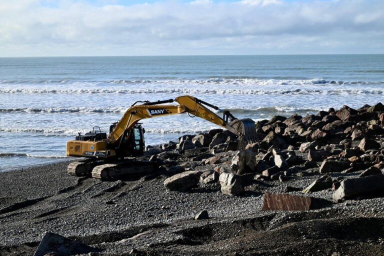 Vista de la construcción del muro de protección costera en Playa Unión, con piedras y hormigón