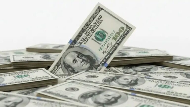 Billetes de dólar estadounidense junto a un billete de 1000 pesos argentinos