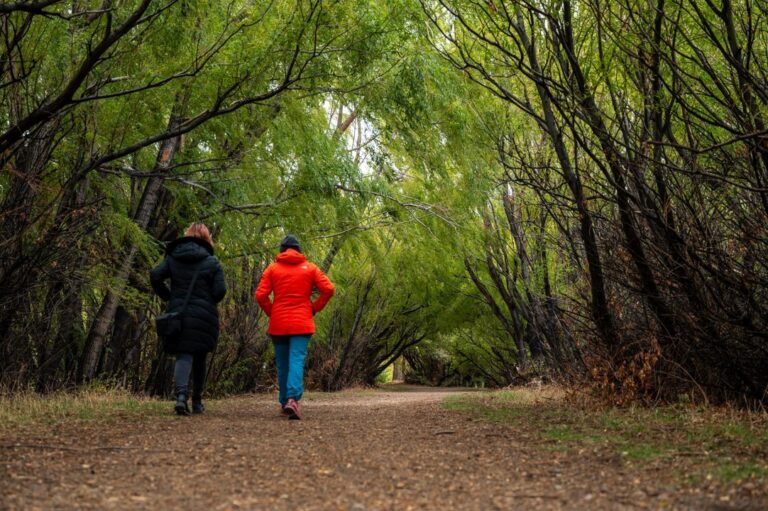 Mujeres caminando por un sendero entre chacras en Sarmiento, Chubut
