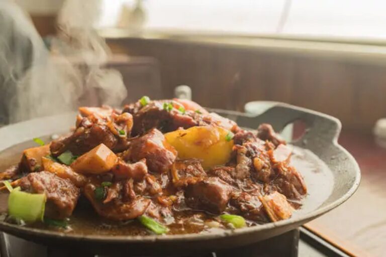 Olla de guiso de carne con verduras sobre una mesa