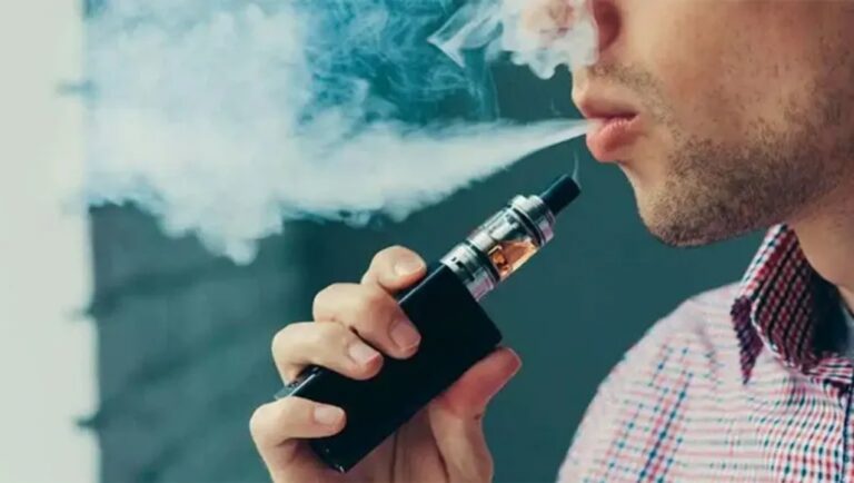 Adolescente usando un vapeador en un entorno urbano