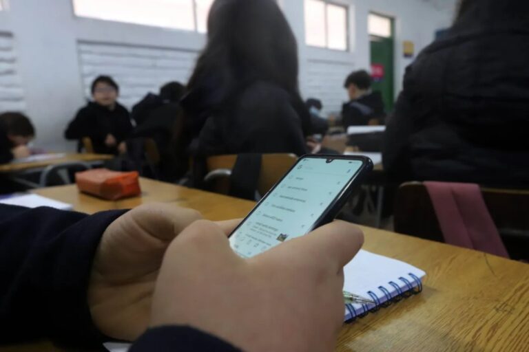 Estudiantes en un aula de Chubut con celulares sobre el escritorio